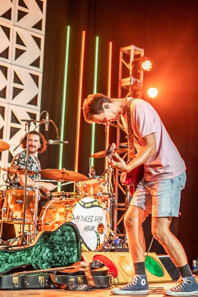 Guitarist performing in front of the drum kit