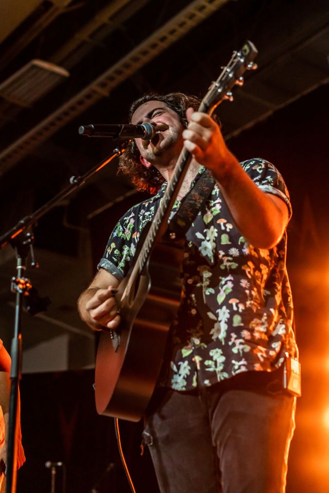 Playing guitar and singing into a microphone
