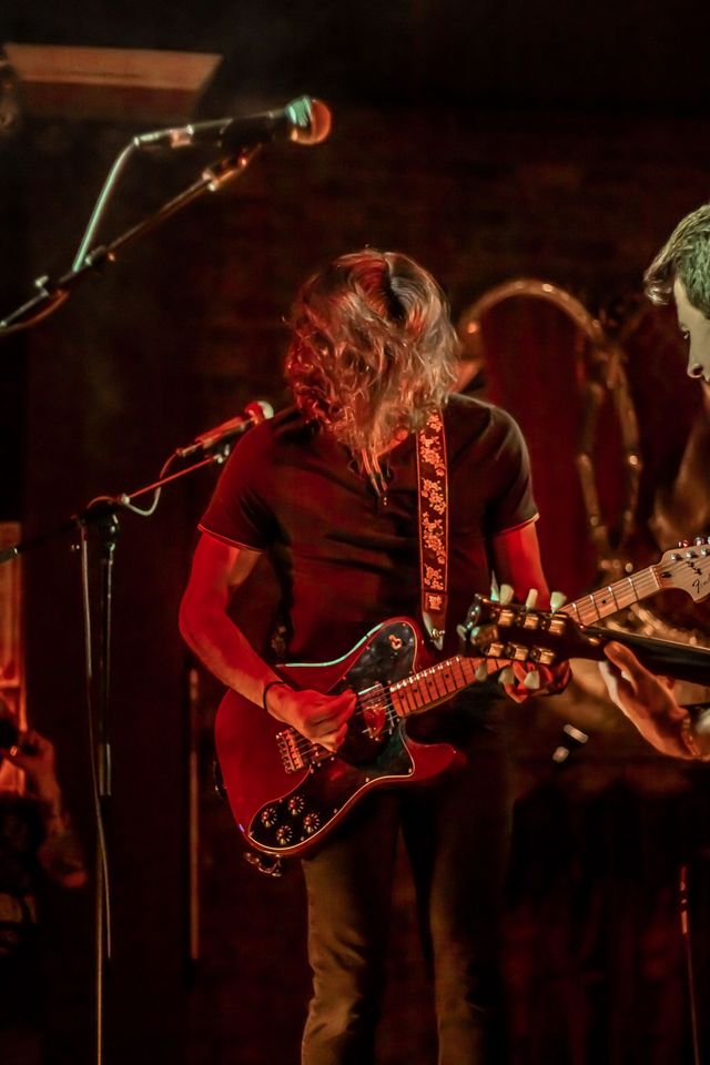 Guitarist singing into a microphone on stage